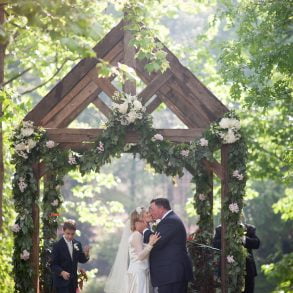 bride and groom kiss under the arch