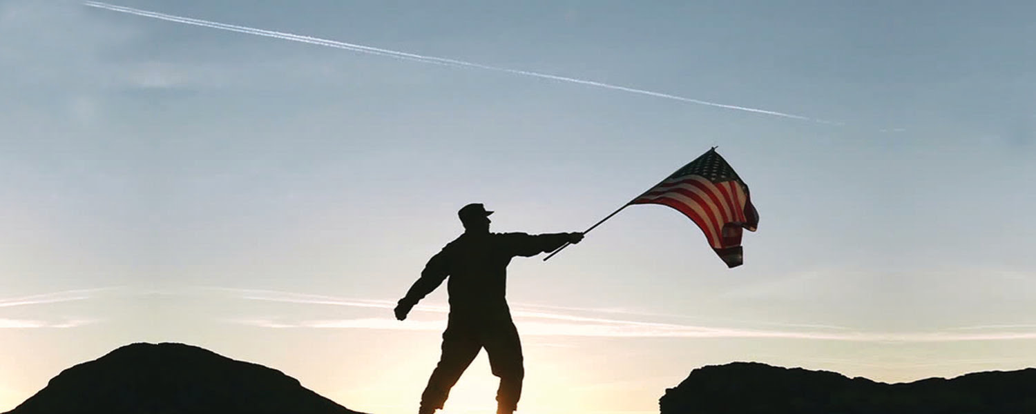 Military servicemember raises a flag to the sky